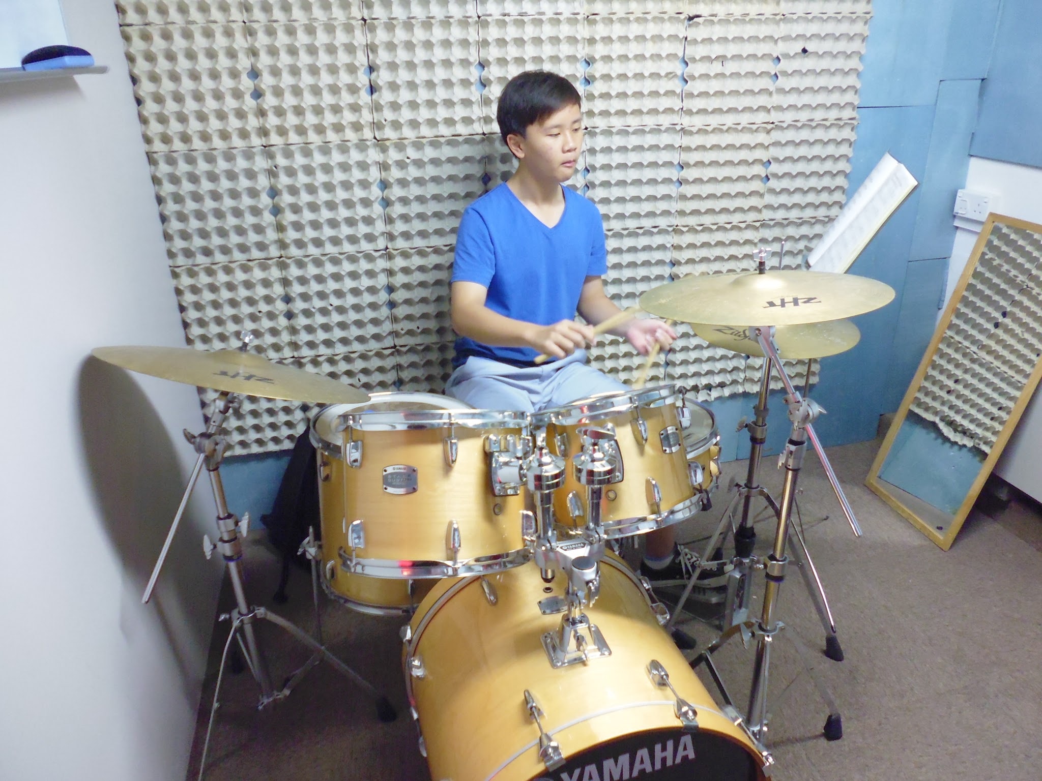 Student playing a Yamaha drum kit during a studio lesson